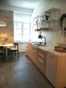a kitchen with a sink and a refrigerator and a table at Lovely apartment in the city center in Pula