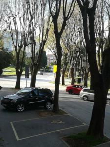 a black car parked in a parking lot next to trees at Lovely apartment in the city center in Pula