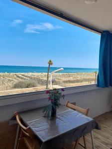 una sala da pranzo con tavolo e vista sulla spiaggia di T3 avec magnifique vue mer a Le Barcarès