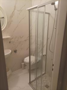 bagno con doccia in vetro e servizi igienici di Hotel Amica a Rimini