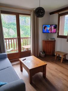 a living room with a couch and a coffee table at T2 Les Chardons avec Piscine Sauna et Hammam in Valloire