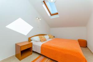 een slaapkamer met een bed met een oranje deken bij Apartments Dijana in Slano