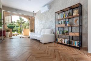 a living room with a white couch and book shelves at Aloni Hotel Pefkochori in Pefkochori