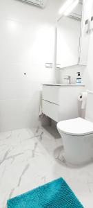 a bathroom with a toilet and a sink and a mirror at TORRE La MATA Apartamento in La Mata