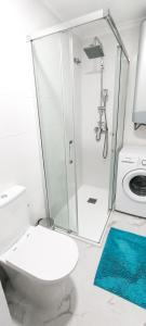 a white bathroom with a toilet and a shower at TORRE La MATA Apartamento in La Mata