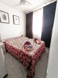a bedroom with a bed with a red blanket and a window at TORRE La MATA Apartamento in La Mata