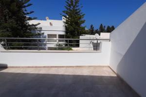 een balkon met uitzicht op een wit huis bij LEO Haute standing appartment S1 center Monastir in Monastir