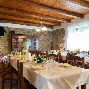 ein Esszimmer mit Tischen und Stühlen mit weißem Tischtuch in der Unterkunft Pietra del Colle Agriturismo in Altavilla Silentina