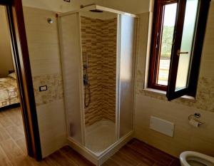 una doccia con porta in vetro in bagno di Pietra del Colle Agriturismo ad Altavilla Silentina