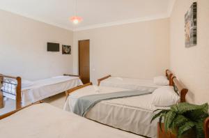 a hospital room with three beds and a tv at Marcos Hotel in Nizhnyaya Alekseyevka