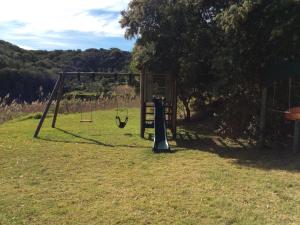 a swing set in the middle of a field at Long Thin Farm in Stilbaai