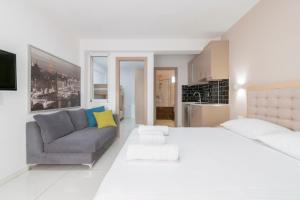a white bedroom with a bed and a couch at Art Studios in Neos Marmaras +54 photos