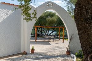 an archway leading to a patio with a table at Hotel Villa Cedrino in Dorgali