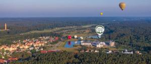 two hot air balloons flying over a small town at Natur Camp Glamping Birštonas in Birštonas