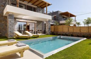 a swimming pool in the backyard of a house at Volta Suites and Villas in Kato Gouves +45 photos