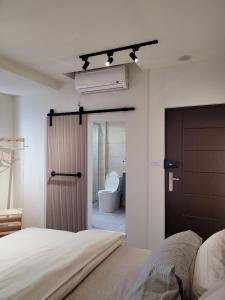1 dormitorio con 1 cama y baño con aseo en Good Day Homestay en Nangan