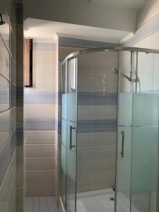 a glass shower stall in a bathroom with at Pensiunea DeeaMar in Năvodari