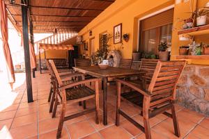 uma mesa de madeira e cadeiras num pátio em Casa rural Villa Cristina Almonacid de Toledo em Almonacid de Toledo