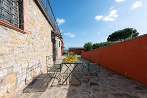 a table with flowers on it next to a brick building at Agriturismo Le Case Rosse di Montebuono in Magione