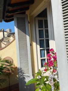 una casa con ventana y una planta con flores rosas en Al Campanile, en Florencia