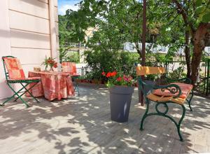 un patio con 2 sillas y una mesa con flores en Room soba u Opatiji Na Lipovici en Opatija