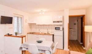 a small kitchen with a table and a microwave at Studio in Stinjan/Istrien 17366 in Štinjan