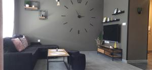 ein Wohnzimmer mit einem Sofa und einer Uhr an der Wand in der Unterkunft Top Studio Vinica in Warna