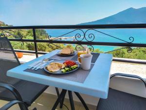 a blue table with a plate of food on a balcony at Celeste Golden Beach in Chrysi Ammoudia