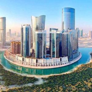 an aerial view of a large city with tall buildings at Cozy Upgraded Residential Flat with sea, Mangrove, pool view - 1203 in Abu Dhabi