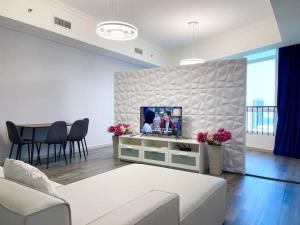 a living room with a couch and a tv on a wall at Cozy Upgraded Residential Flat with sea, Mangrove, pool view - 1203 Not Hotel in Abu Dhabi
