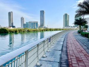 a walkway next to a body of water with buildings at Cozy Upgraded Residential Flat with sea, Mangrove, pool view - 1203 Not Hotel in Abu Dhabi