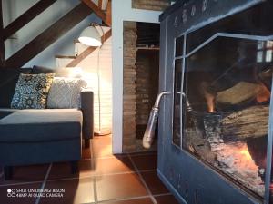 a living room with a fireplace and a couch at Casa de aldea la tienda de Villanueva in Colombres +52 photos
