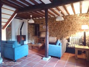 sala de estar con 2 sofás azules y chimenea en Alojamiento rural la tienda de Villanueva, en Colombres