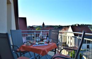 a balcony with a table with a bottle of wine at Ferienwohnung Anneliese am Stadttor in Hornbach