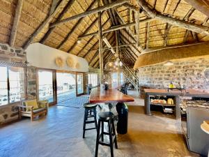 a kitchen with a table and chairs in a building at Tugela River Lodge in Winterton