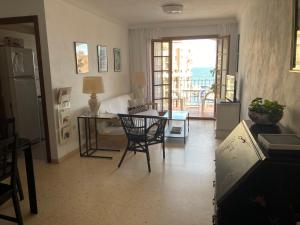 uma sala de estar com uma secretária e uma mesa com uma cadeira em Apartamento Mirador De La Darsena em Port Saplaya