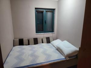 a small bed in a room with a window at Katarina Apartment Kotor in Dobrota