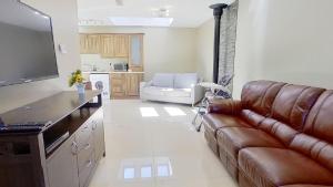 uma sala de estar com um sofá e uma televisão em Harbour View, Mullaghmore, Sligo em Sligo
