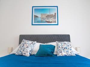 a bed with blue sheets and pillows in a bedroom at Apartment Matea in Mokošica