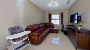 a living room with a leather couch and a television at Harbour View, Mullaghmore, Sligo in Sligo
