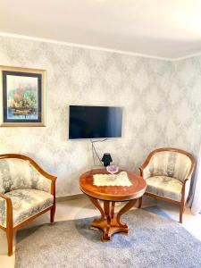 uma sala de estar com duas cadeiras e uma mesa e uma televisão em LUNGOMARE em Split