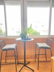 una mesa con dos sillas y una mesa con una planta. en Ático Parque Natural Cabo de Gata en Retamar
