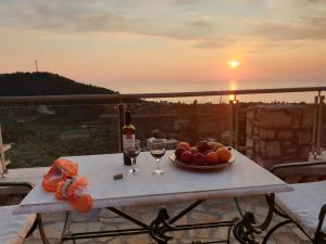 a table with a bowl of fruit and wine glasses at Lavender House 1 - Agios Nikitas in Agios Nikitas