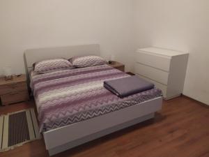 ein Schlafzimmer mit einem Bett mit einer lila Bettdecke in der Unterkunft Apartmani Noemi Pula in Pula