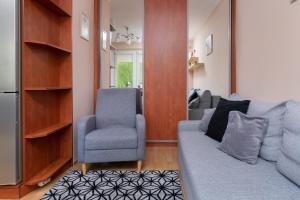 a living room with a couch and a chair at Gdansk Zabianka Sztormowa Apartment with 1 Bedroom by Renters in Gdańsk