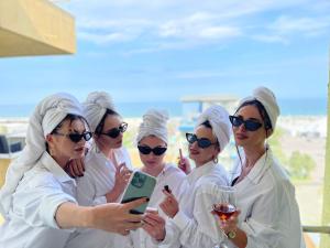 un grupo de mujeres vestidas de blanco mirando sus celulares en Summerland apartments and Alezzi apartments en Mamaia