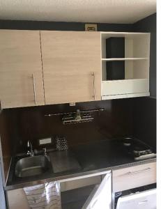 kuchnia ze zlewem i białymi szafkami w obiekcie Appartement 4pers rénové aux Menuires w Les Menuires