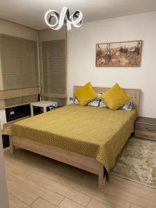 - une chambre avec un grand lit et des oreillers jaunes dans l'établissement Luxery stay with seaview, pool, green space & Sunset orientation near Rabat, à Sidi Bouqnadel