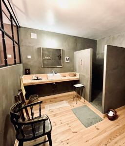 a bathroom with a tub and a sink and a chair at La Madeleine in Amplepuis