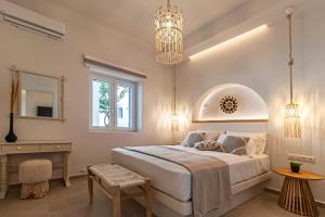 a bedroom with a bed and a desk and a chandelier at Juliano luxury apartments, port of Naxos in Naxos Chora